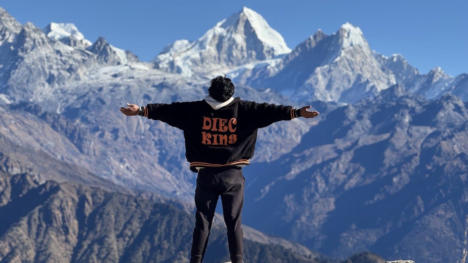 Arms wide before the Himalayan range